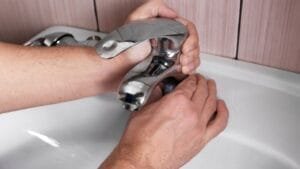 Carefully tightening a tap fitting with an adjustable spanner during repair